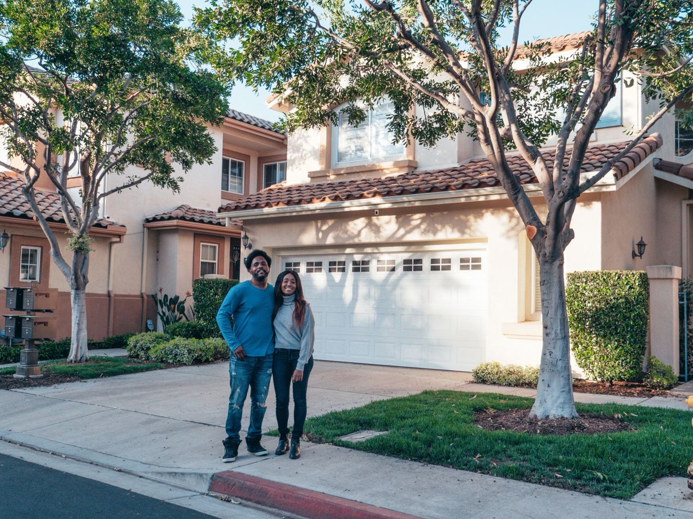 Couple standing in front of their home, representing a move from Los Angeles to Canyon Country in Santa Clarita