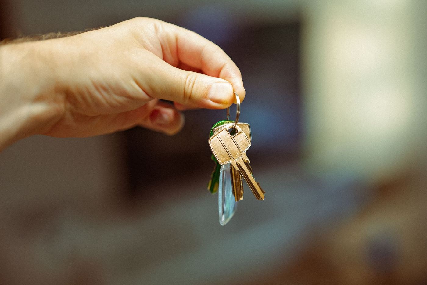 Hand holding house keys, representing the real closing costs of buying a home in Santa Clarita