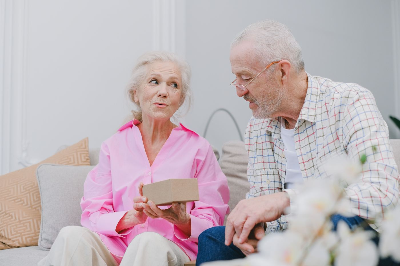 Older couple sitting together sorting a small keepsake box while downsizing their Saugus home