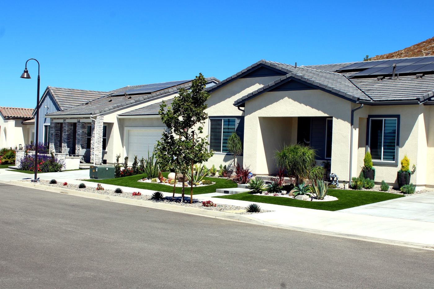 Newer hillside HOA neighborhood street in Saugus, CA with solar-roofed homes, part of Santa Clarita