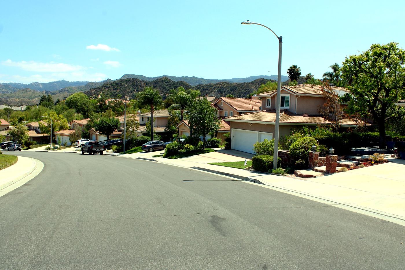 Hillside street of two-story homes with red tile roofs in Stevenson Ranch, Santa Clarita