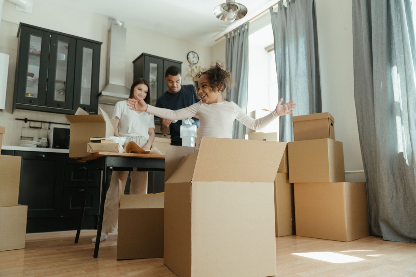 Family unpacking moving boxes together in their new kitchen, Stevenson Ranch, Santa Clarita