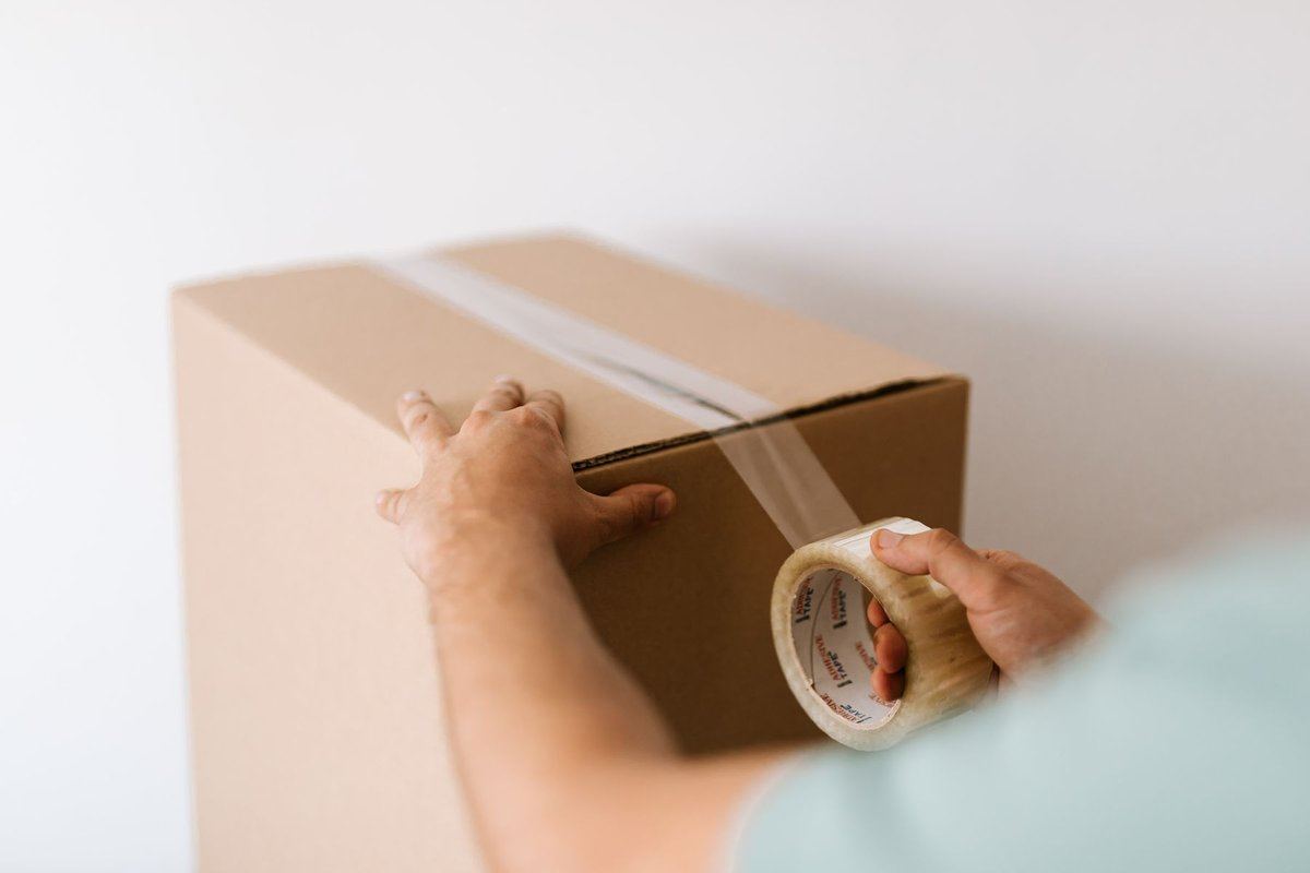Hands taping a moving box in preparation for a Santa Clarita home sale